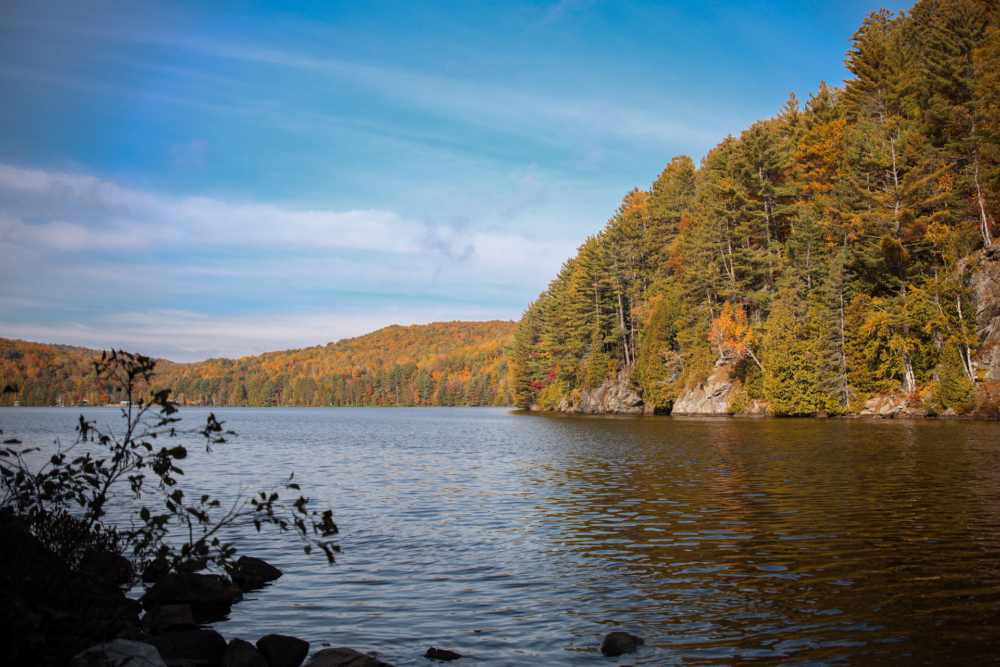 Lac paisible entouré de forêts aux couleurs automnales, un décor naturel près des chalets de Chalets Lanaudière.