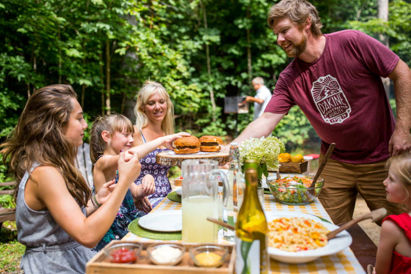 Famille profitant d’un repas convivial en plein air lors d’un séjour en chalet de Chalets Lanaudière.
