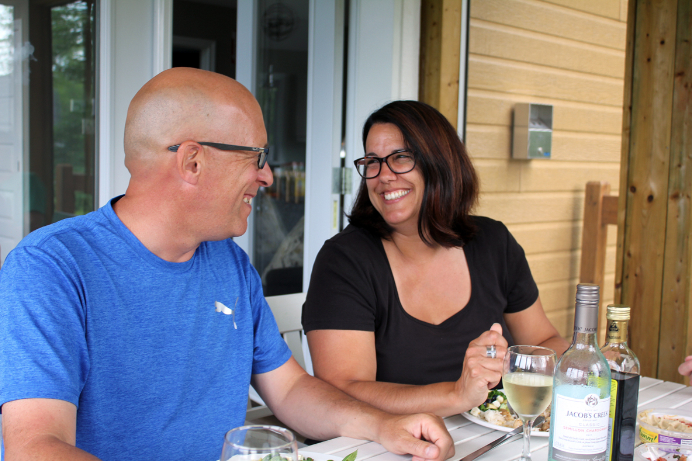 Couple profitant d’un repas convivial sur la terrasse d’un chalet de Chalets Lanaudière.
