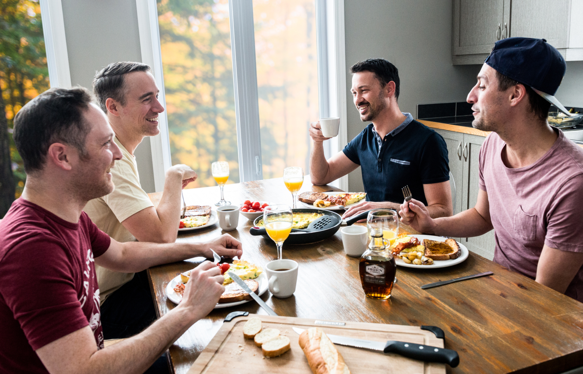 Groupe d’amis partageant un repas convivial dans la cuisine d’un chalet de Chalets Lanaudière.