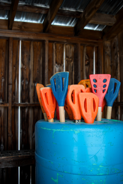 Outils de plage colorés dans un baril bleu, à l’intérieur d’une cabane rustique de Chalets Lanaudière.