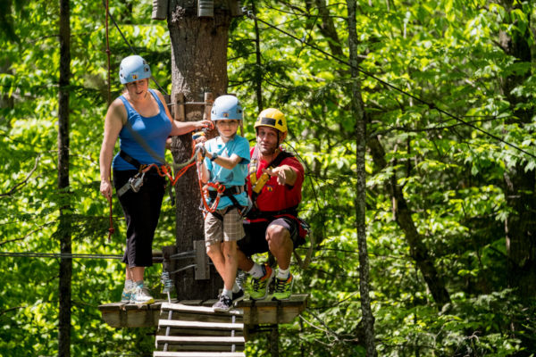 Groupe profitant d’un parcours d’hébertisme aérien en forêt lors d’un séjour aux Chalets Lanaudière.
