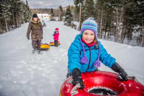 Enfants profitant d’une journée de glissade en famille lors d’un séjour en chalet aux Chalets Lanaudière.