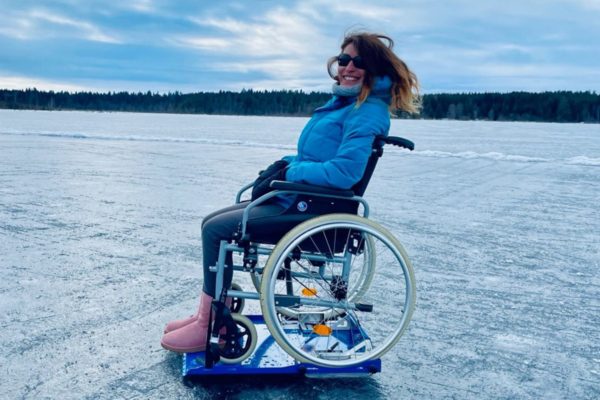 Personne en fauteuil roulant profitant d’une sortie hivernale sur un lac gelé près des chalets Lanaudière.