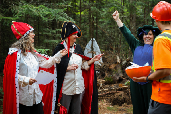 Groupe en costumes historiques et personne en tenue de chantier profitant d’une activité en forêt près des chalets Lanaudière.