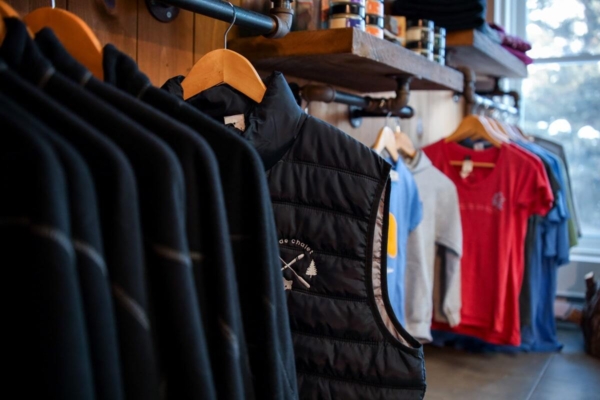 Sélection de vêtements et de gilets suspendus dans la boutique des Chalets Lanaudière.