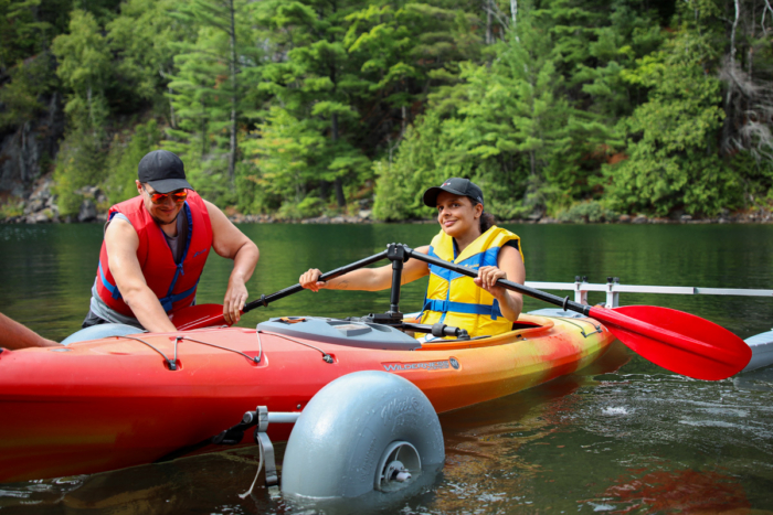 Personnes pagayant en kayak sur un lac près d’une forêt, lors d’un séjour dans un chalet de Chalets Lanaudière.