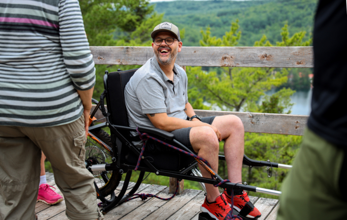 Personne en fauteuil roulant adapté profitant d’un belvédère en nature lors d’un séjour aux Chalets Lanaudière.