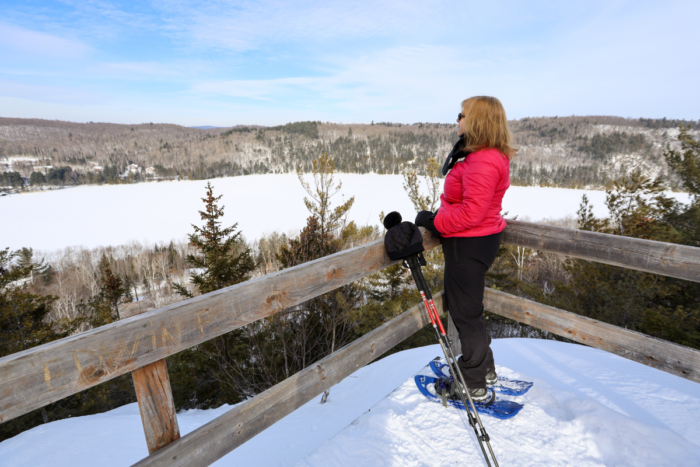 Skieuse admirant le paysage enneigé depuis une plateforme panoramique près des chalets de Chalets Lanaudière.