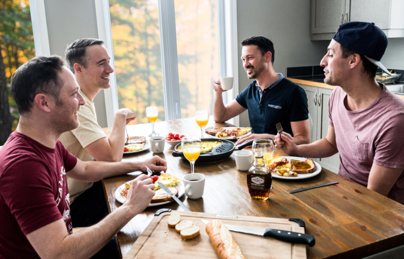 Groupe d’amis partageant un repas convivial dans la cuisine d’un chalet de Chalets Lanaudière.