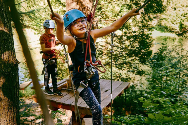 Enfant faisant de l’accrobranche sur un parcours en forêt lors d’un séjour aux Chalets Lanaudière.
