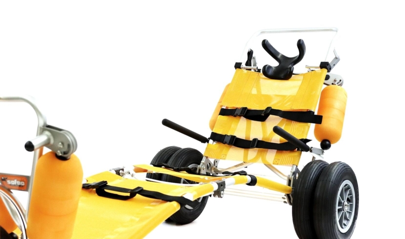 Fauteuil roulant tout-terrain jaune, adapté aux déplacements sur la plage et offert comme équipement accessible aux vacanciers.