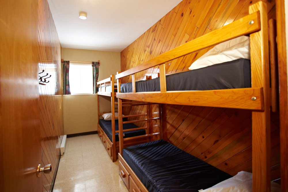 Chambre avec lits superposés en bois dans un chalet.
