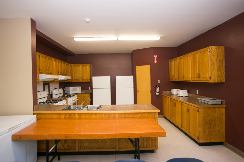 Cuisine entièrement équipée d’un chalet, avec îlot central en bois, armoires et appareils électroménagers.
